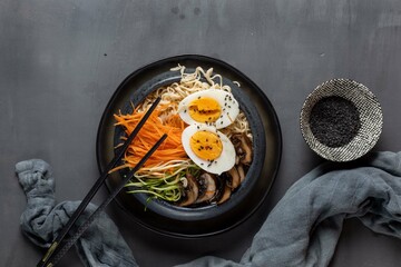 Miso ramen with mushrooms, carrots, zucchini and eggs on a dark background,top view,copy spase