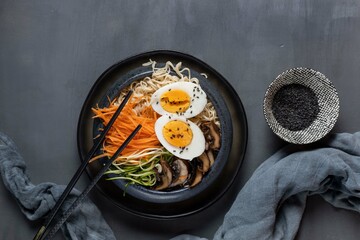 Miso ramen with mushrooms, carrots, zucchini and eggs on a dark background,top view,copy spase