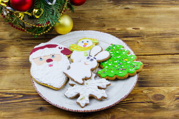 Fototapeta na wymiar Christmas gingerbread cookies in a plate and Christmas decoration on a wooden table