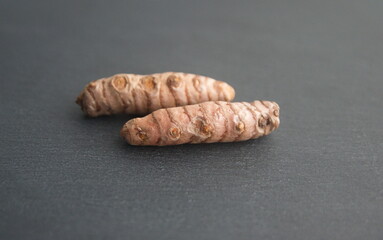 Curcuma, turmeric, Curcuma longa - perennial herbaceous plant, medicinal use,  food seasoning rhizome, on grey background