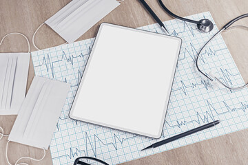 Top view of wooden desktop with empty tablet, stethoscope, cardiogram, pen, other items and mock up place. Doctor's office, workplace and diagnosis concept. 3D Rendering.
