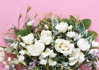 Delicate blooming festive white roses on pink background, blossoming rose flowers with green leaves, soft pastel frame, bouquet floral card, selective focus