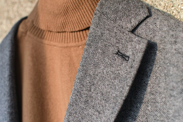 Grey woolen blazer combined with brown fashionable sweater.  Low DOF. Selective focus.