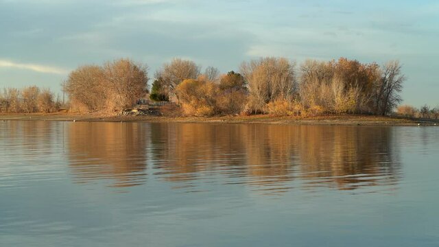 sunset light on a calm lake in November scenery - picnic area in Boyd Lake State Park in northern Colorado