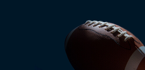 American football ball close up on dark background. Horizontal sport theme poster, greeting cards,...