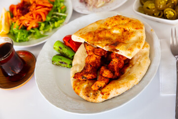 Appetizing spicy chicken shish taouk (Sis tavuk) served with lavash and vegetables. Traditional...