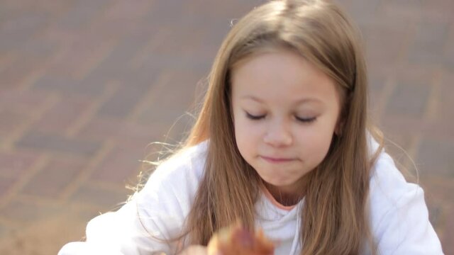 Portrait of smiling child sneezing, scratching nose and eats a croissant, seasonal allergy
