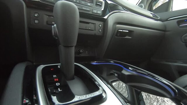 The gear shift lever in a modern SUV. Car interior in black. filmed with fisheye