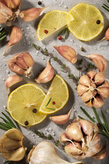 Garlic, rosemary, lemon  on grey background. Spices, herbs, parsley, top view.