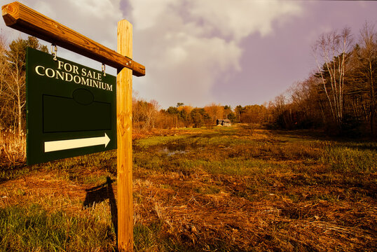 For Sale Sign In The Countryside Pointing Toward A Old House