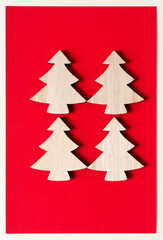 four plain wood christmas tree cutouts on red paper