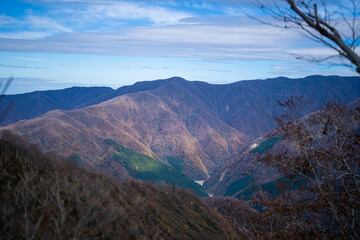 入善町、黒部宇奈月温泉や白馬岳を眺められる富山県入善町の負釣山を紅葉の時期に登山する風景 A view of climbing Mt.Oiturushiyama in Nyuzen-cho, Toyama Prefecture, with views of Kurobe Unazuki Onsen and Mt.Shirouma-dake, during the season of autumn