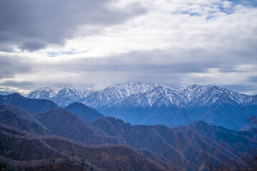 Naklejka premium 入善町、黒部宇奈月温泉や白馬岳を眺められる富山県入善町の負釣山を紅葉の時期に登山する風景 A view of climbing Mt.Oiturushiyama in Nyuzen-cho, Toyama Prefecture, with views of Kurobe Unazuki Onsen and Mt.Shirouma-dake, during the season of autumn