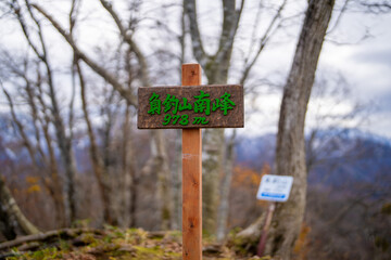 Naklejka premium 入善町、黒部宇奈月温泉や白馬岳を眺められる富山県入善町の負釣山を紅葉の時期に登山する風景 A view of climbing Mt.Oiturushiyama in Nyuzen-cho, Toyama Prefecture, with views of Kurobe Unazuki Onsen and Mt.Shirouma-dake, during the season of autumn