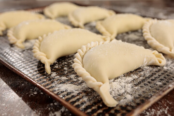 close up of empanadas in a baking dish ready to cook. Traditional South American food.