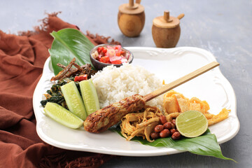 Nasi Campur Bali. Balinese Dish of Steamed Cone Shaped Rice with Variety of Side Dishes, such as Sate Lilit, Ayam Pelalah, Telur Dadar, Kacang Teri, Sambal Matah, Jukut Urap.