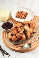 Vanilla Bread and Butter Pudding with Raisins in Clear Baking Dish, Served with Vla