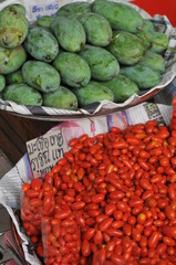 tomatoes and mangoes at a market in Bang, Thailand.