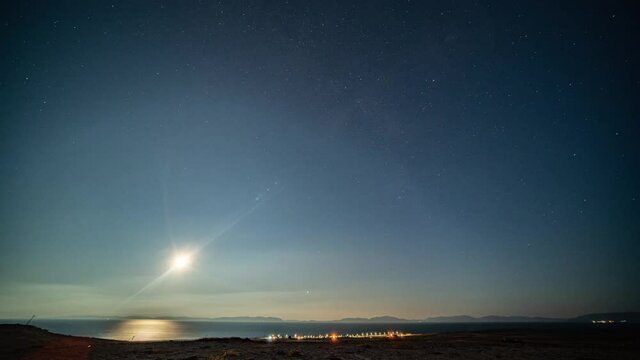 Full night  timelapse. Moon passing over the night sky. Bright splashes of the northern lights.