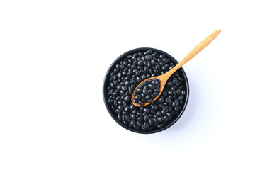 Black soy bean seeds in a wooden bowl with spoon on white background