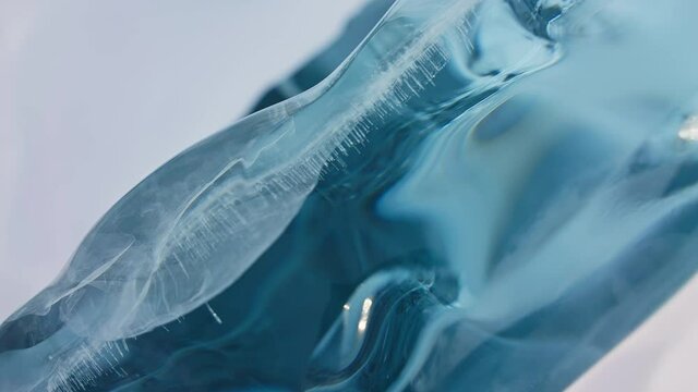 Smooth polished glazed blue ice slab. Detailed glacial surface, tracking shoot.