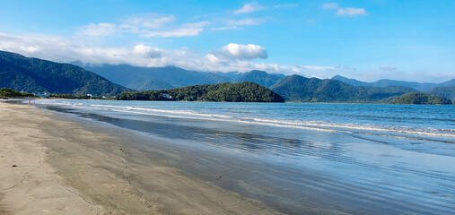 Tropical beach with dark sands due to oil
