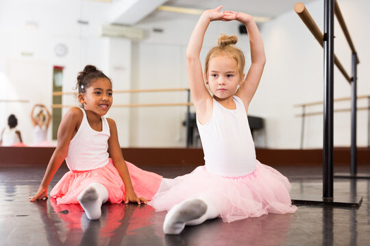 Portrait of two little ballerinas practicing choreography in dance hall