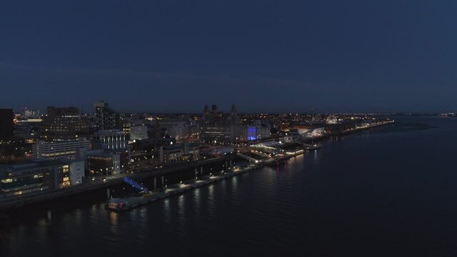River Mersey, River of Light, Liverpool, England. Night time. Drone flys forward and tilts down. 4k