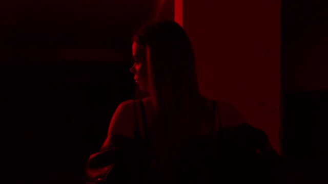 beautiful girl in red lighting sitting