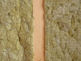 Rock wool insulation between wooden studs. Insulation of walls in a wooden frame house with rock wool. Residential frame construction