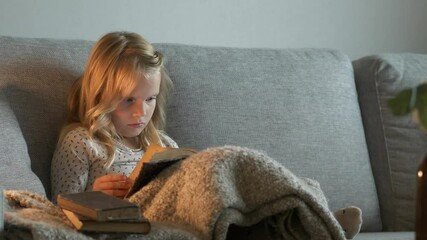 Young child reading old book in Cozy Sofa
