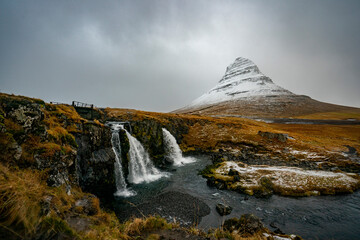 Kirkjufell mountain in Iceland sits covered in snow.