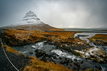 Kirkjufell mountain in Iceland sits covered in snow.