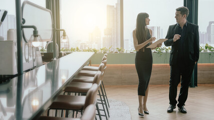 Caucasian businessman and Latin businesswoman in the office, Co-working space, ask for opinions take notes on paper.