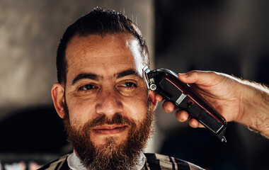Closeup of trimmer machine. Process of trimming of hair in barber shop.