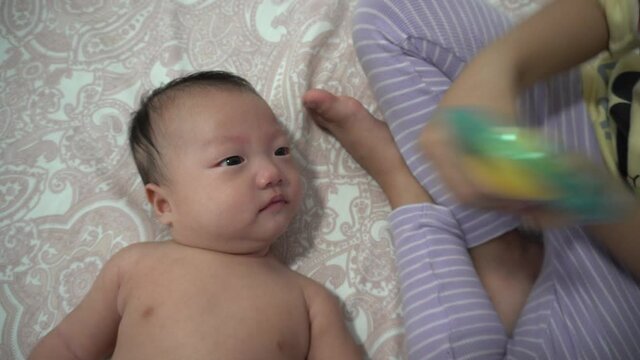Sister play rattle to y to baby boy. Infant boy yawning