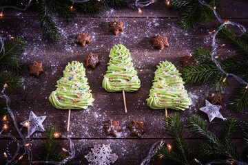 Close up of green Christmas tree meringues on wooden background. Holiday concept, christmas, new...