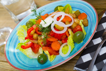 Salad with lettuce, olives and baked carrots, eggplant, bell pepper