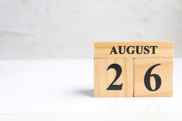 Hello August, Cube wooden calendar showing date on 26 August. Wooden calendar with date on a light background.