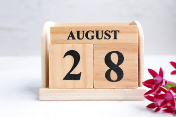 Hello August, Cube wooden calendar showing date on 28 August. Wooden calendar with date on a light background.