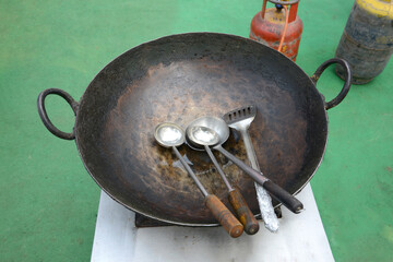 Fototapeta na wymiar Close Up of empty iron wok and ladles