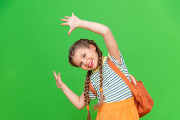 a little girl with a briefcase is fooling around a lot. Green isolated background.