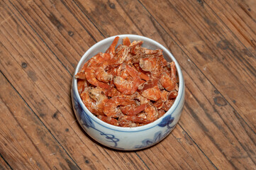 Fototapeta na wymiar Shelled fresh shrimps on a plate or bowl are on a wood colored table