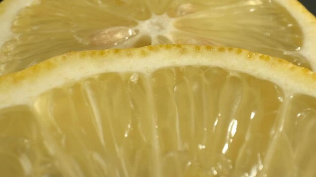 Round slices of yellow lemon with seeds on a dark background. Fruits for the preparation of lemon juice. The concept of using citric acid in medicine. High quality. 4k footage.