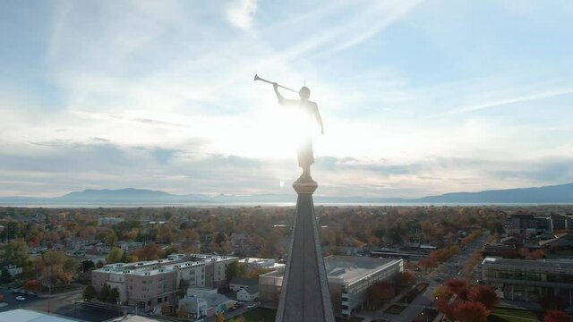 Angel Moroni Statue with Trumpet atop LDS Mormon Temple at Sunset in Provo, Utah - Aerial Orbit