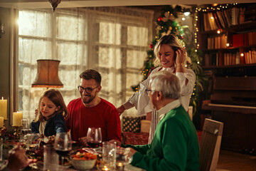 Cheerful family having lunch together on Christmas eve at home