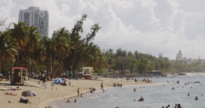 Persons relaxing lying around on the shore at Balneario del Escambron, San Juan, Puerto Rico