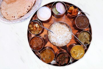 Dham - Traditional food of Himachal Pradesh. Himachali kangri dham thali includes Kaddu ka khatta, Chane ka Madra, sepu vadi, maash dal, Rajma, salad, rice, or Mitha Bhaat. served with Roti and pickle