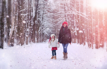 Fototapeta na wymiar A winter fairy tale, a young mother and her daughter ride a sled in the forest. A girl on a sled with gifts on the eve of the new year in the park. 