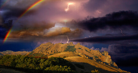 Rainbow and lightning over the rocky coast of the Black Sea, Crimea,  Stunning view of the storm over the rocky cliffs of the Karadag mountain range, near Koktebel, Eastern Crimea. 
